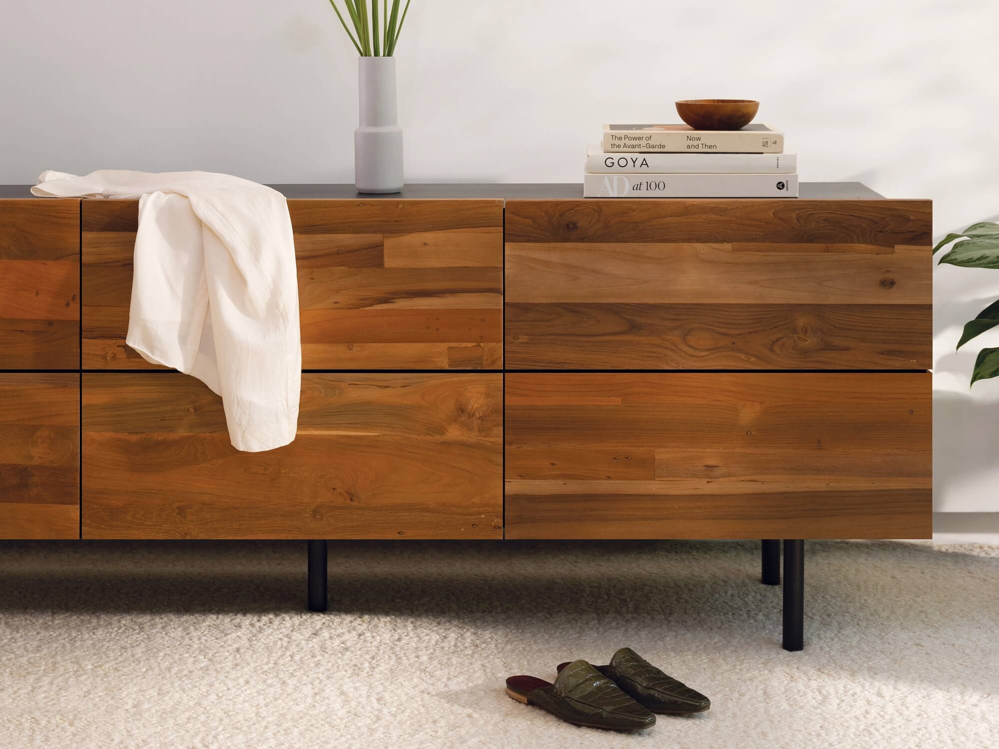 The Reclaimed Teak Modern Dresser with candles and vases on top in a sunny bedroom with hardwood floors